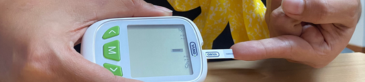 YANO Foto de una persona usando un glucometro inteligente para medir su nivel de glucosa en sangre en un ambiente hogareño