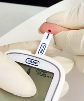 Foto de una persona utilizando el glucometro YANO para medir su glucosa en sangre