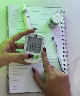 Imagen de una mujer utilizando un glucómetro YANO en su trabajo, mostrando la importancia del monitoreo constante